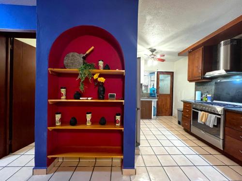 a kitchen with a red and blue wall at Casa Revolucion: 2BR/2Ba Casita close to downtown with private parking in Cabo San Lucas