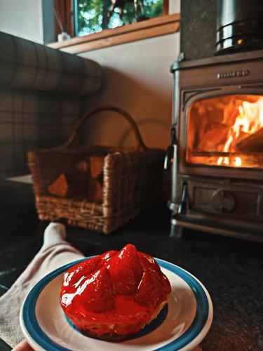 a red object on a plate in front of an oven at Rowanlea Lodge With Hot Tub in Marykirk