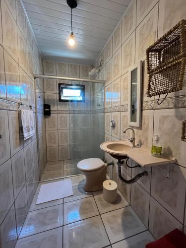 a bathroom with a shower and a toilet and a sink at Casa com suíte in Blumenau