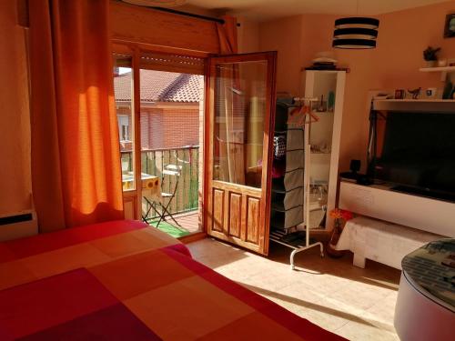 a living room with a sliding glass door to a balcony at Habitación privada, siéntete como en tu casa in Manzanares el Real