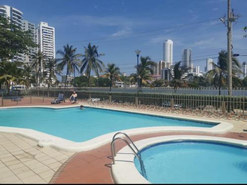 een groot zwembad met een stad op de achtergrond bij Apartamento con hermosa vista al mar, Cristoforo en el Laguito Cartagena a pocos pasos de la playa in Cartagena