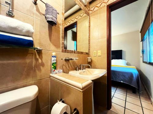 a small bathroom with a sink and a bed at Casa Revolucion: 2BR/2Ba Casita close to downtown with private parking in Cabo San Lucas