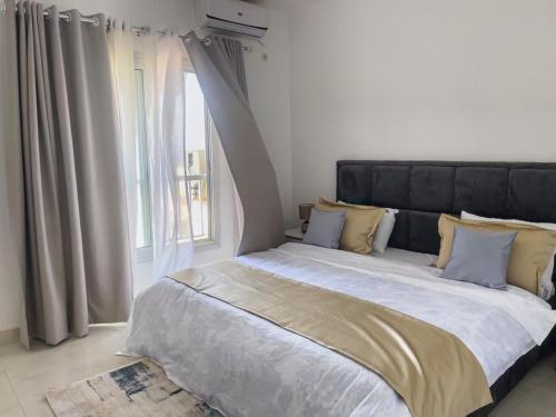 duże łóżko w pokoju z oknem w obiekcie ESPACE VIRAGE w mieście Dakar