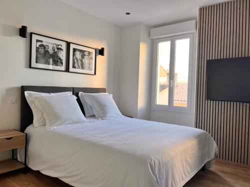 une chambre avec un lit avec des draps blancs et une fenêtre dans l'établissement Appartement comme une suite d’hôtel, à Cannes