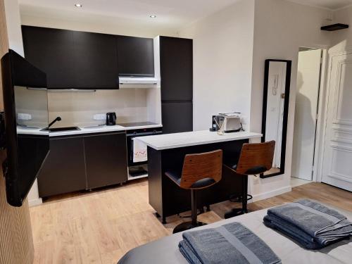 - une petite cuisine avec 2 chaises et un comptoir dans l'établissement Appartement comme une suite d’hôtel, à Cannes