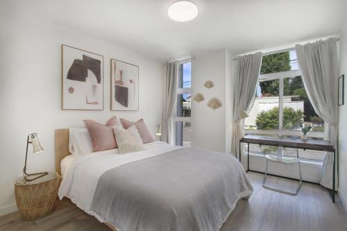 ein weißes Schlafzimmer mit einem Bett und einem Fenster in der Unterkunft Gorgeous NEW Townhome on Capitol Hill, Close to Everything! in Seattle