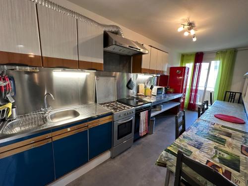 une cuisine avec un évier et une cuisinière dans l'établissement Appartement entier 