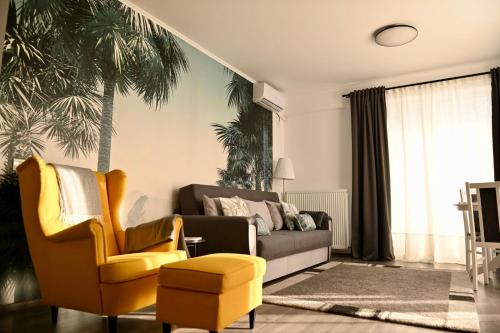 a living room with a couch and a yellow chair at Mathias Airport Residences & Therme-Self Check-in in Otopeni
