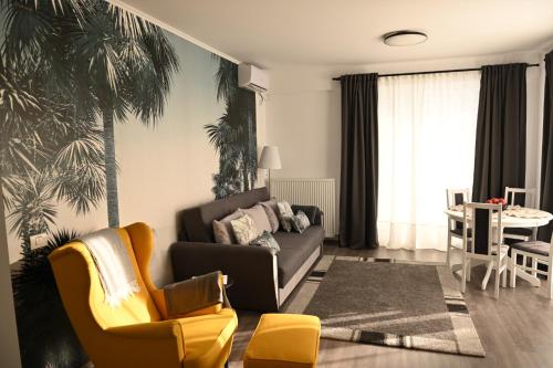 sala de estar con sofá y silla en Mathias Airport Residences & Therme-Self Check-in en Otopeni
