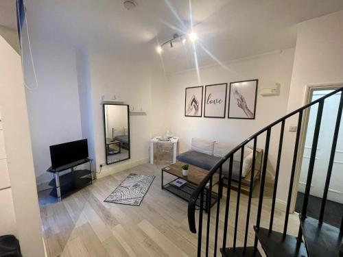 un salon avec un escalier et une télévision dans l'établissement Self Contained 1 Bedroom Duplex, à Leicester