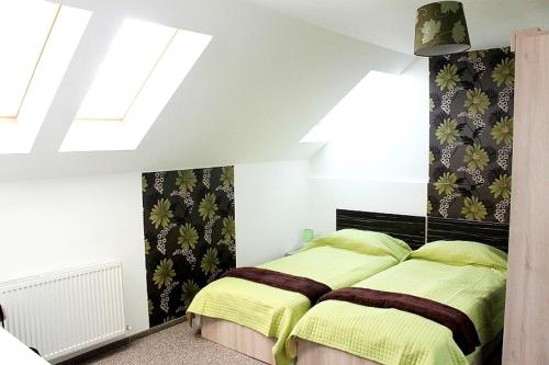 a bedroom with a bed with yellow sheets and a window at Pension Daciana in Bacău