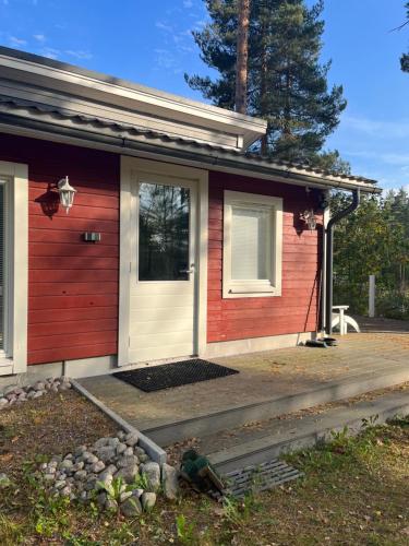 a small red house with a white door at Vuolenkosken Helmi - laadukas ympärivuotinen kohde in Huutotöyry