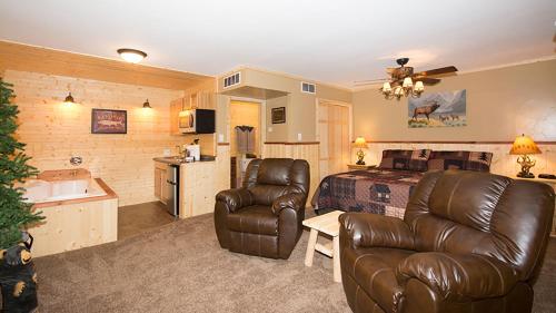 a bedroom with a bed and a leather couch at Upper Canyon Inn & Cabins in Ruidoso
