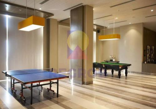 a ping pong table in a room with two tables at EzyStay Boutique Suites in Lucknow