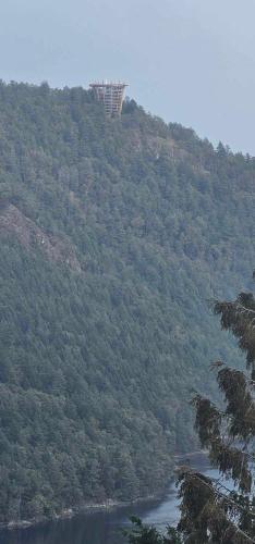 a view of a hill with a river and a tower at Moon Water Lodge in Malahat