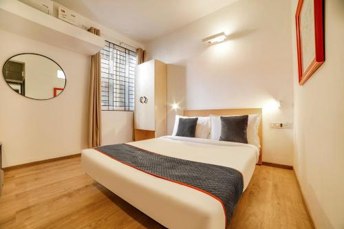 1 dormitorio con 1 cama grande y espejo en Townhouse 361 Sarvar Hospitality Near Ascendas Park Square Mall, en Bangalore