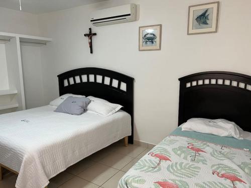 バイア・キノにあるConVal beach houseのベッドルーム1室(ベッド2台付)が備わります。