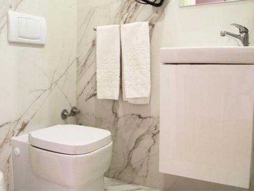 a white bathroom with a toilet and a sink at Bemyguest - Loft Guest House Jardim das Mães Charming in Viseu