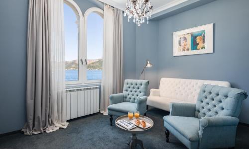 a living room with a couch and chairs and a window at Aminess Younique Korcula Heritage Hotel in Korčula