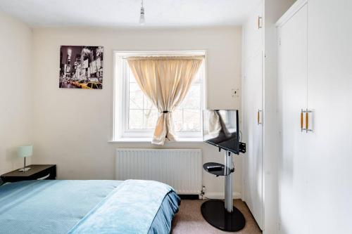 1 dormitorio con cama y ventana en Morden House, en Morden