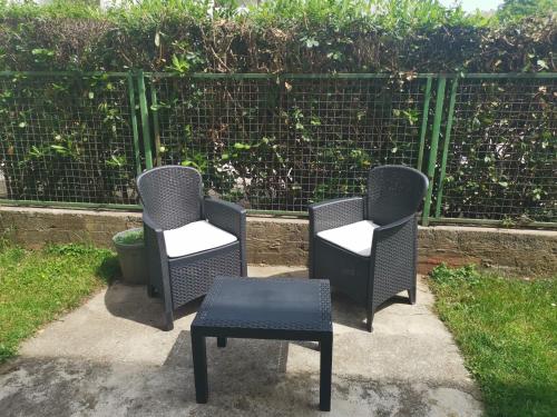 three chairs and a table in front of a fence at Art Apartment in Podgorica