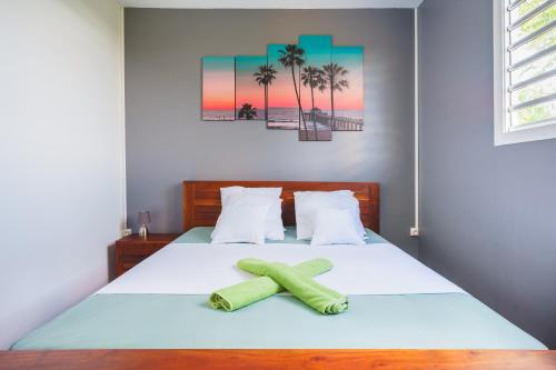 a bedroom with a bed with two towels on it at Charmante Maison 10min de la mer in Sainte-Anne