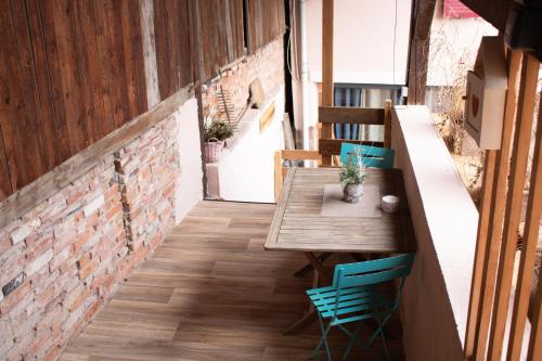 d'une table et de chaises sur un balcon avec un mur en briques. dans l'établissement Chez Rozenn et Mewen, à Romanswiller