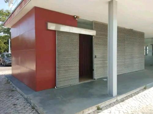 a building with a red wall and a door at Veleiro em Belém in Lisbon