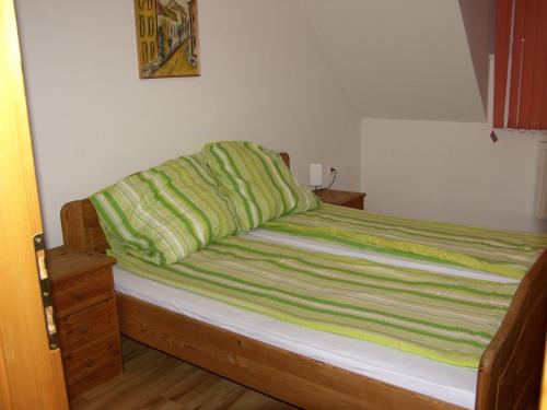 カロチャにあるHunyadi Apartmentのベッド(上に緑の毛布付)