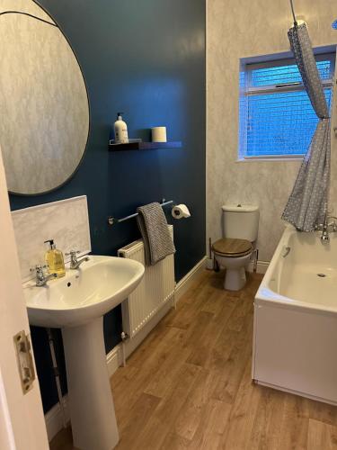 a bathroom with a sink and a toilet and a mirror at Stylish apartment in Walmer (nr Deal&Dover) in Walmer