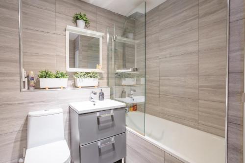 a bathroom with a toilet and a sink and a mirror at Luxurious House With Garden in Perth