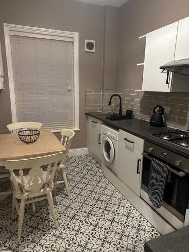 a kitchen with a table and a washing machine at Stylish apartment in Walmer (nr Deal&Dover) in Walmer