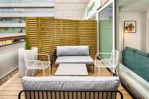 a seating area with a couch and two chairs at Holiday Inn Milton Keynes Central by IHG in Milton Keynes