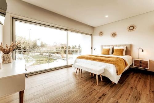 a bedroom with a large bed and a large window at Quinta Chão do Ribeiro in Carvalhal