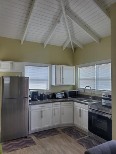 a kitchen with white cabinets and a stainless steel refrigerator at La Pelle in Soufrière