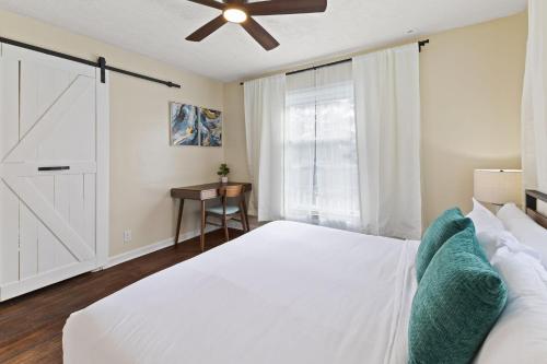 a bedroom with a white bed and a ceiling fan at Charming Home in Speedway in Indianapolis