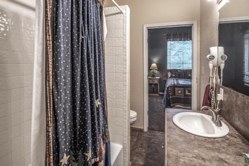 a bathroom with a toilet and a shower curtain at Upper Canyon Inn & Cabins in Ruidoso