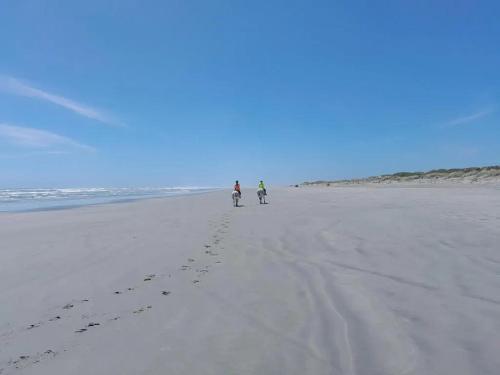 2 personnes font du vélo sur la plage dans l'établissement Beaconstone Eco Stay - off grid retreat, à Charleston