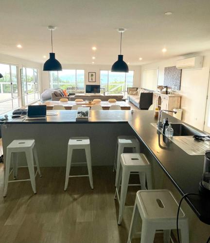 Una cocina con encimera y taburetes en una habitación. en Seas The Day, en Emu Bay