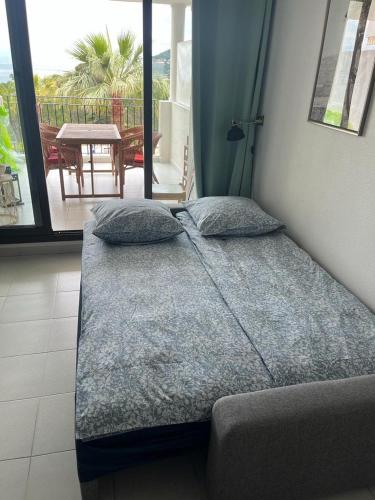 Cette chambre comprend un lit avec des oreillers et un balcon. dans l'établissement Pool , 150m to beach, seaview, à Villefranche-sur-Mer