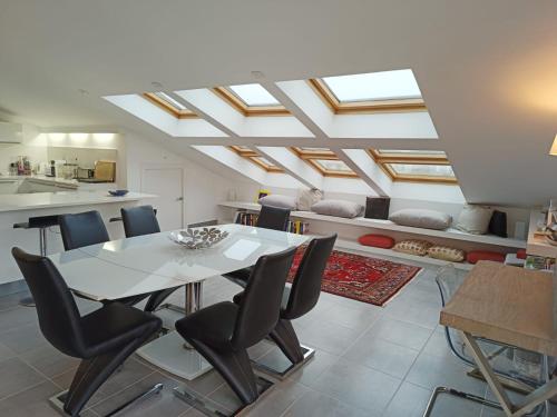 une salle à manger avec une table et des chaises blanches dans l'établissement Patio d'Azur toit terrasse haut de gamme 3 ch jacuzzi coeur de ville et plage, à Saint-Raphaël