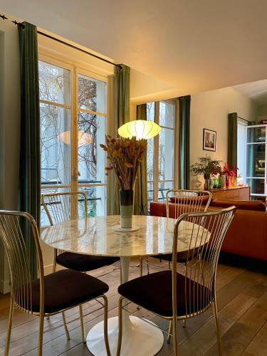une salle à manger avec une table et des chaises dans l'établissement Maison Marais - calme et terrasse, à Paris