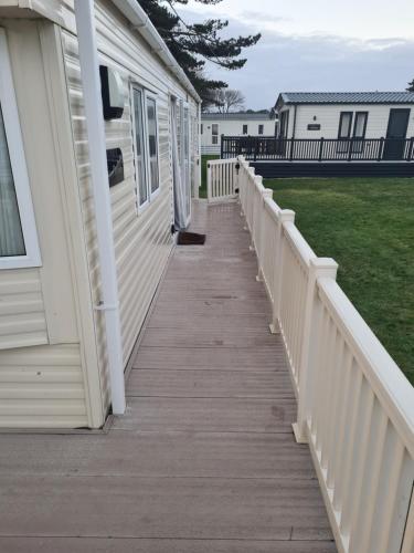 a wooden walkway leading to a porch of a house at Hoburne Naish CS129 in New Milton