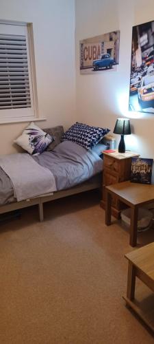 a room with two beds and a table and a lamp at Aylesbury Lovely Double and Single Bedroom with Guest only Bathroom in Buckinghamshire