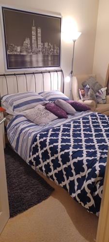a bedroom with a bed with a blue and white comforter at Aylesbury Lovely Double and Single Bedroom with Guest only Bathroom in Buckinghamshire