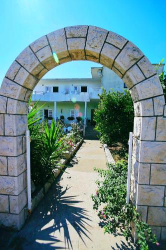 an archway over a walkway in front of a house at Apartments Orest in Sućuraj