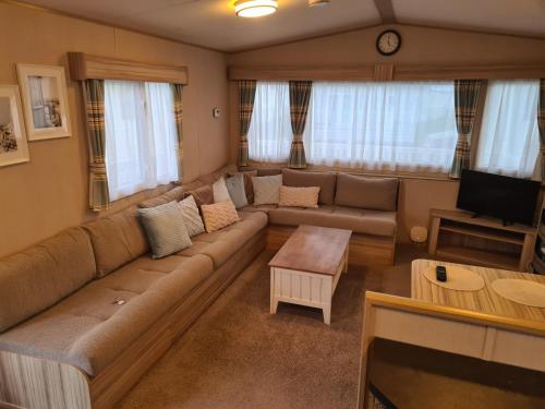 a living room with a couch and a tv at Hoburne Naish CS129 in New Milton