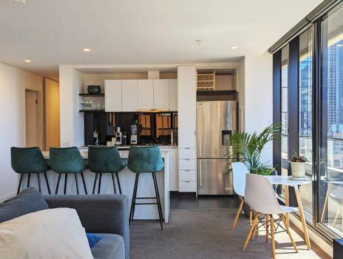 een keuken en een woonkamer met een aanrecht en stoelen bij Breathtaking views of Yarra River and City skyline with Free parking Gym access in Melbourne
