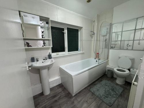 a bathroom with a tub and a sink and a toilet at Noormak nights in Birmingham