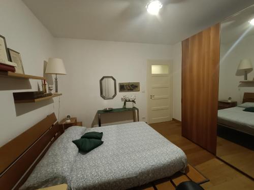 een kleine slaapkamer met een bed en een spiegel bij Casa di Ale in Verona